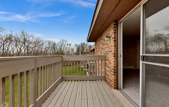 the deck of a home with a view of the yard and the sky