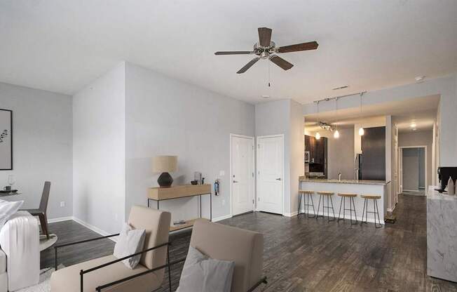 A modern living room with a dining area and kitchen in the background.