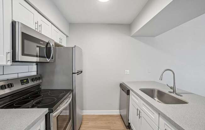 A kitchen with a stove, microwave, and refrigerator.
