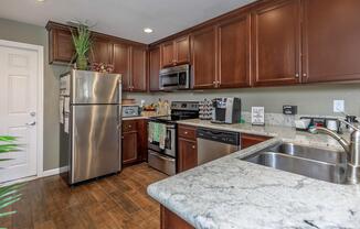 a modern kitchen with stainless steel appliances and wooden cabinets