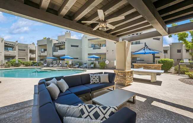 A patio with a pool and a blue couch.