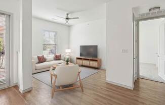 A living room with a white chair and a wooden floor.