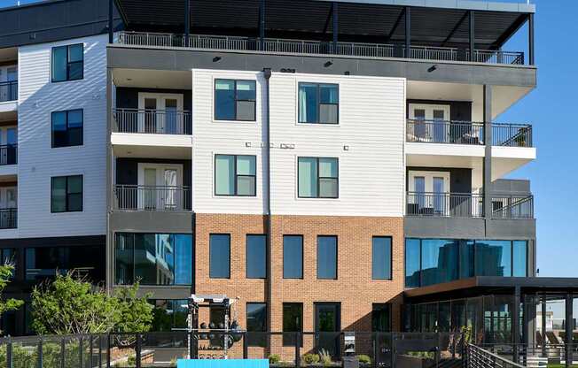 A modern apartment building with a green lawn in front.