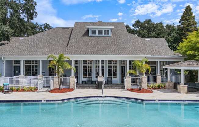 A house with a pool in front of it.