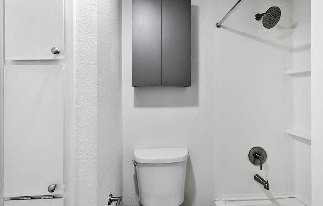 A white toilet in a bathroom with a white door and a white wall.