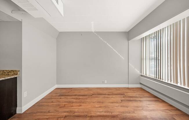 an empty living room with wood flooring and a large window