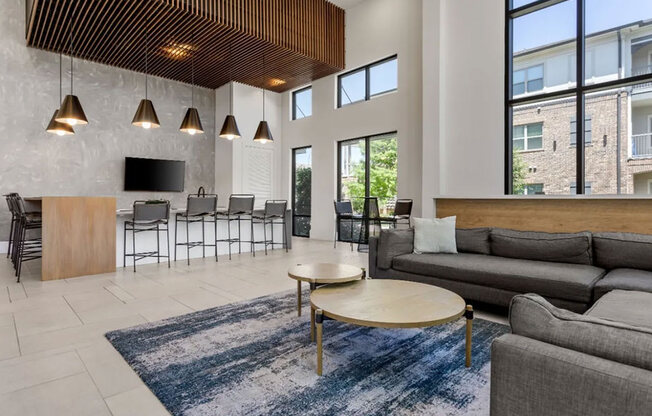 A modern living room with a wooden ceiling and a large window.