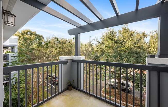 a balcony with a view of a parking lot and trees