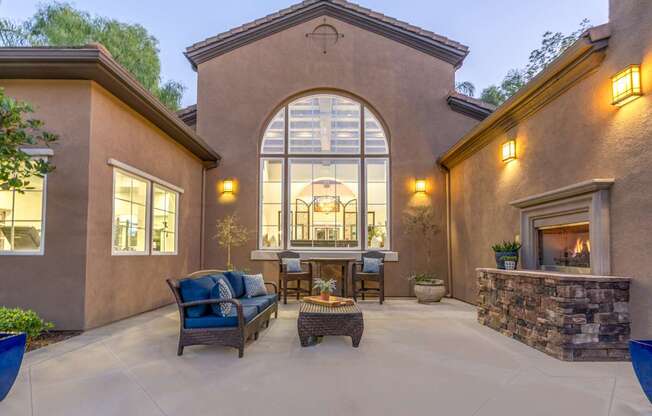 A patio with a stone fireplace and a couch.