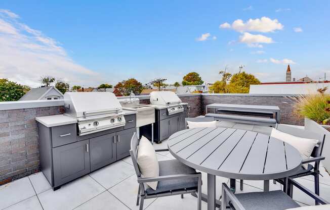 an outdoor patio with stainless steel appliances and a table and chairs
