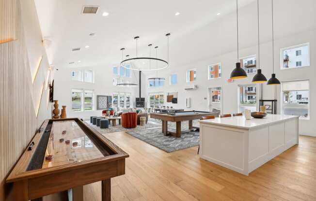 a living room with a ping pong table and a kitchen