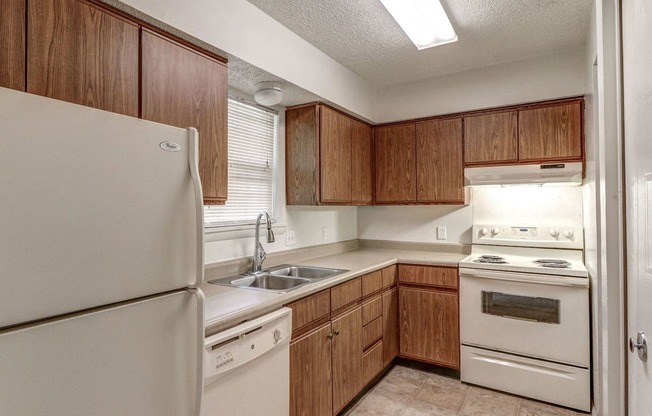 Townhome kitchen at Ashley Pointe Apartments with white appliances and lots of cabinets