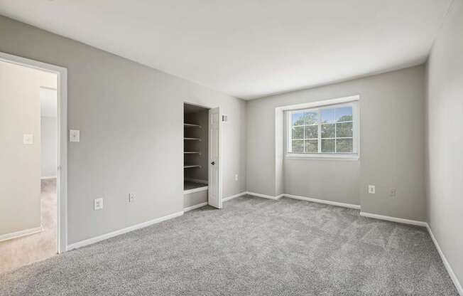 an empty room with carpet and a door to a closet at ReNew Odenton