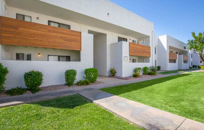 a white building with a green lawn in front of it