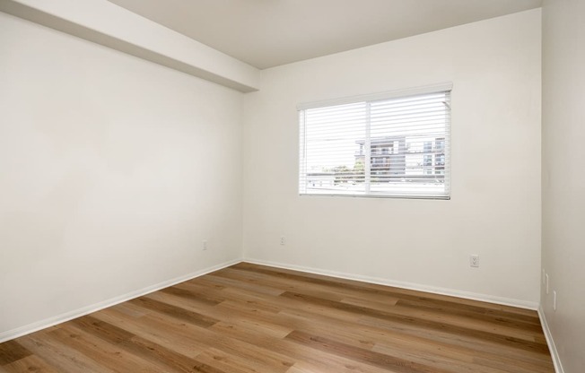 an empty room with white walls and a window