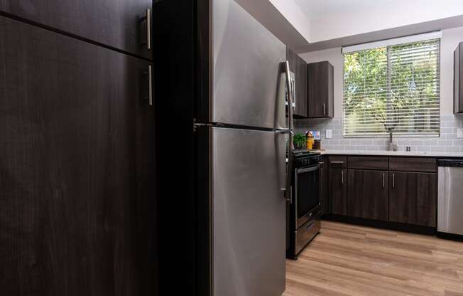 a kitchen with a stainless steel refrigerator and a window