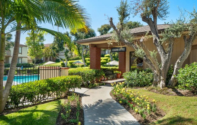 a sidewalk in front of a house with a swimming pool