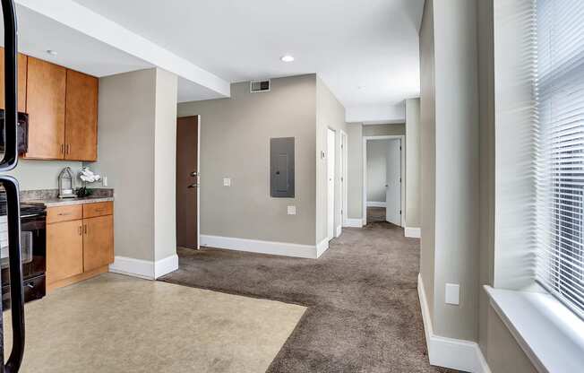 a spacious living room and kitchen with a carpeted floor