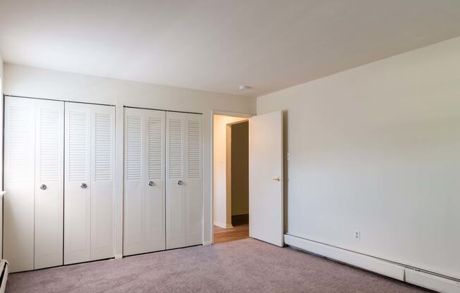 a bedroom with two closets and an open door