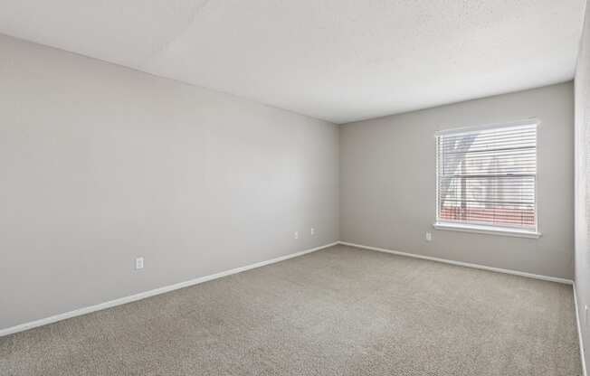 A room with a window covered by blinds.