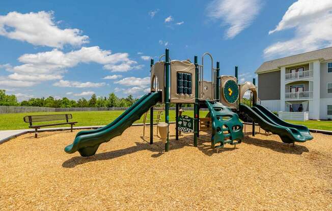 A playground with a green slide and a yellow slide.