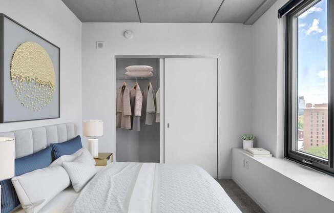 A bedroom with a large bed and a window overlooking a cityscape.