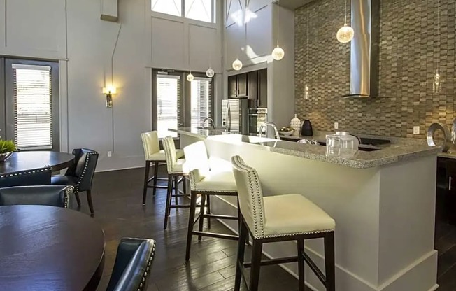 A kitchen with a bar area and chairs.