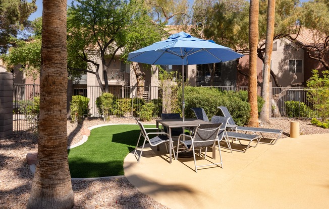 a patio with a table and chairs and an umbrella