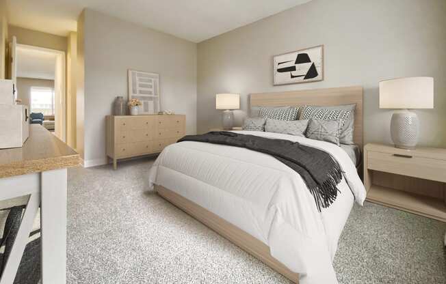 A bedroom with a large bed and a nightstand with a lamp.