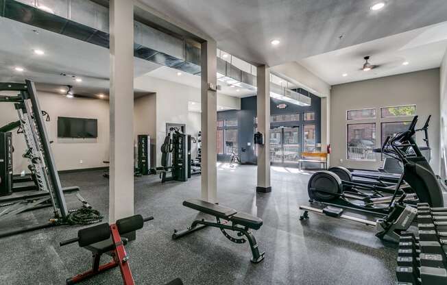 a gym with weights and other exercise equipment and a tv