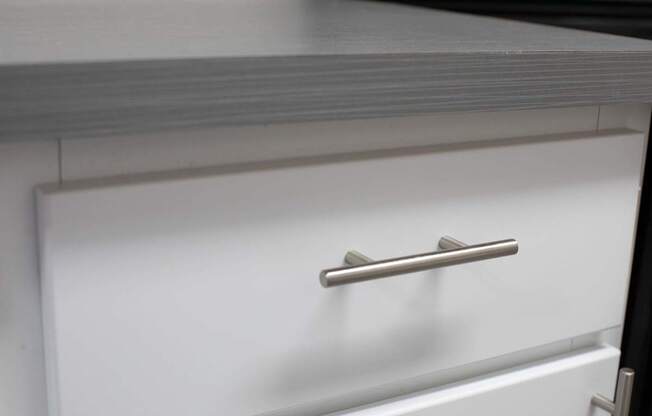 A white drawer with a silver handle is open.