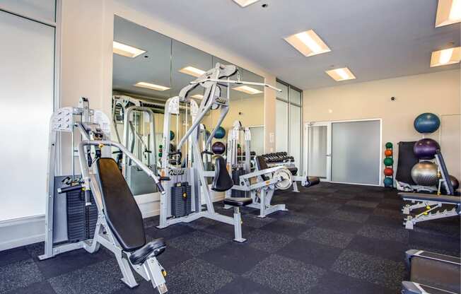 a gym with cardio equipment and mirrors in a building