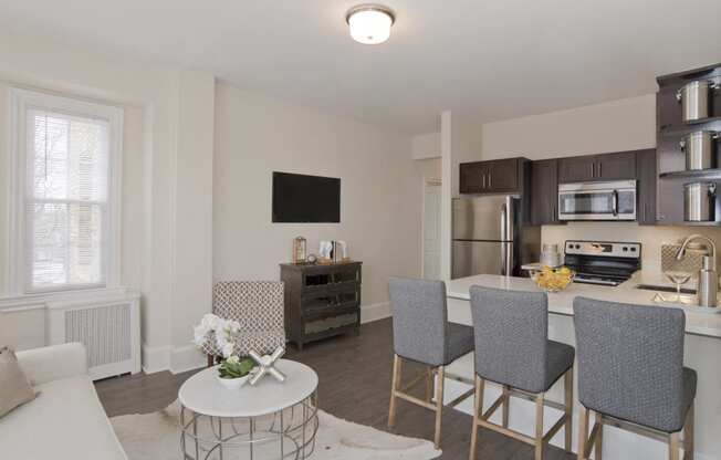 a living room with a kitchen and a table with chairs