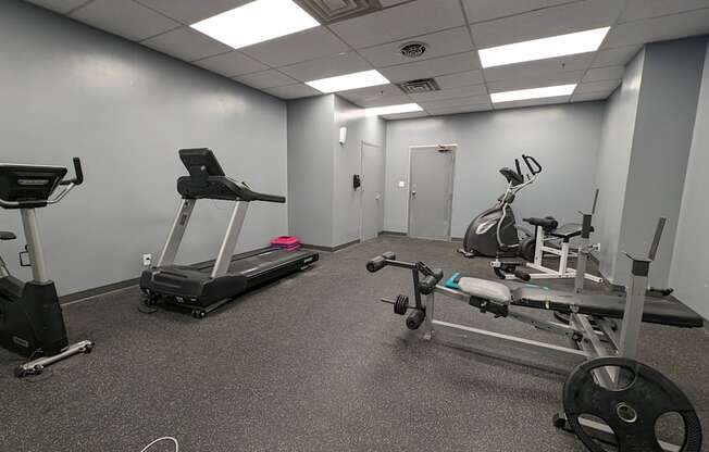 a gym with exercise equipment and weights in a building