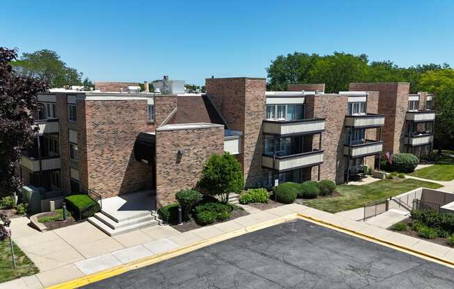 an aerial view of an apartment complex with trees and a blue sky