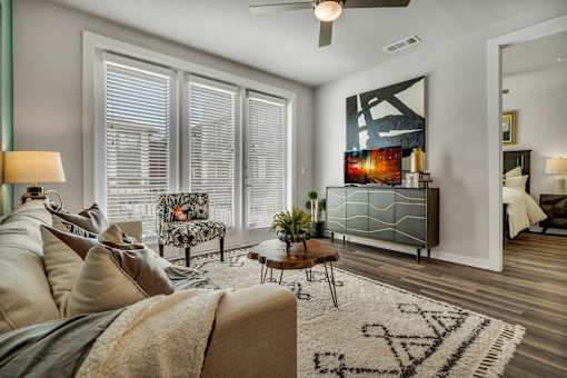 A living room with a couch, a chair, a coffee table, and a large painting on the wall.