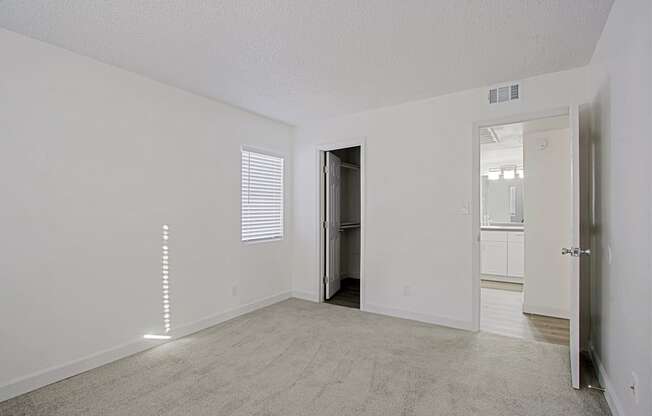 an empty living room with a door to a bathroom