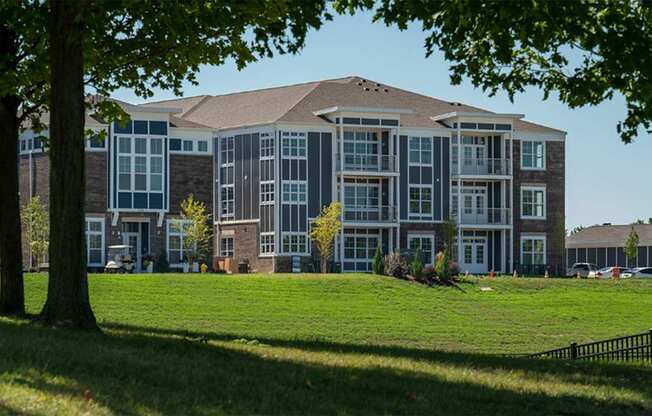 A large, modern building with a grassy lawn in front.