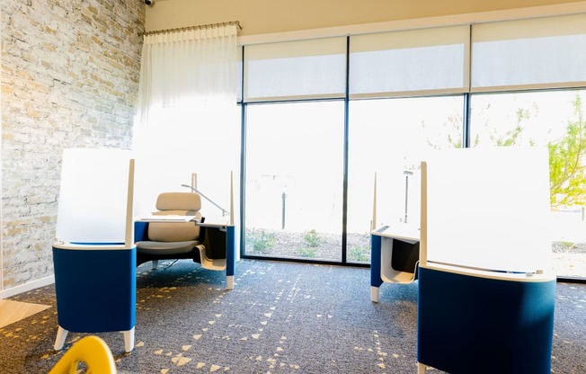 three tables with whiteboards in a room with large windows