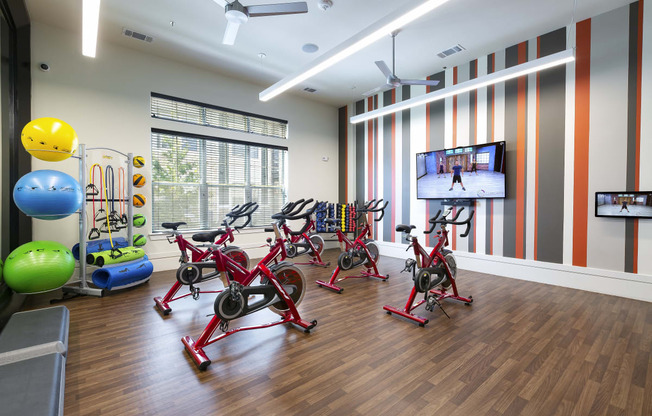 a fitness room with exercise equipment and a tv