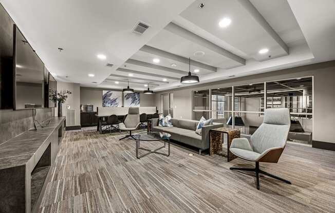 A modern living room with a grey sofa and a wooden floor.