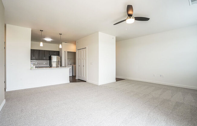 an empty living room with a ceiling fan and a kitchen in the background at Meadowbrooke Apartment Homes, Grand Rapids, 49512