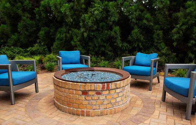 A fire pit surrounded by chairs in a backyard.