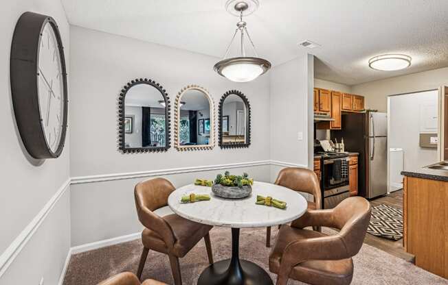 A dining room with a round table and chairs.