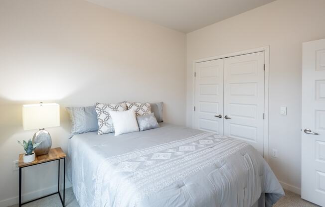 a white bedroom with a white bed and a white closet at Technology Park Apartments, Rochester, 55901