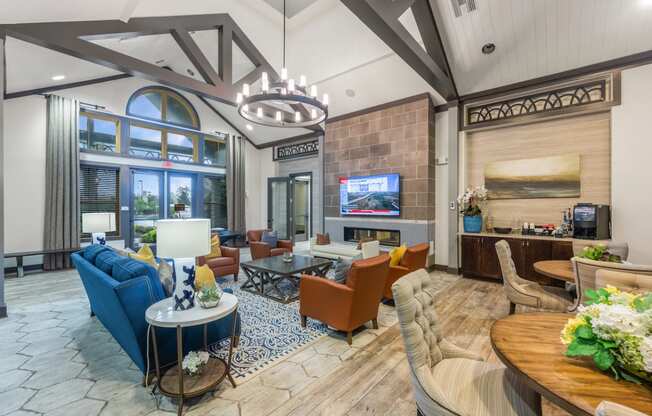 a lobby with couches and chairs and a table and a television