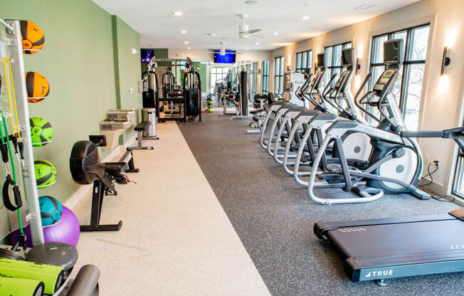a row of cardio machines and weights in a gym