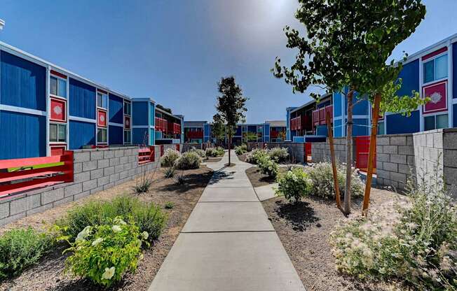 A walkway leads between a row of blue and red buildings.