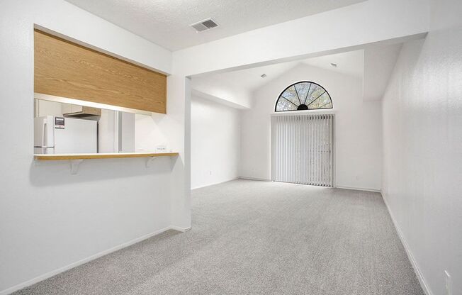 a dining and living room with a cathedral ceiling at Hampton Lakes Apartments, Michigan, 49534
