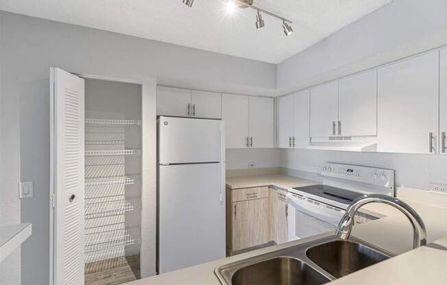 a white kitchen with white appliances and white cabinets
